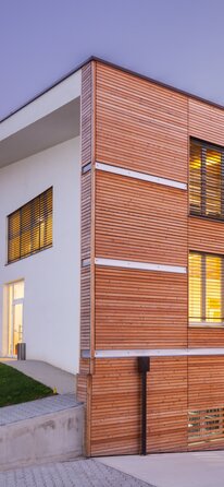 Wooden data centre in Bologna | © Davide Cornacchini A three-storey building at dusk, clad in horizontal wooden slats.  | © Davide Cornacchini